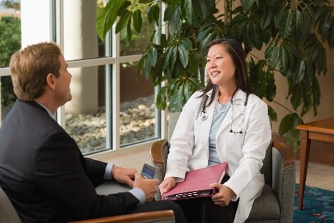 Doctor and businessperson discussing partnership working