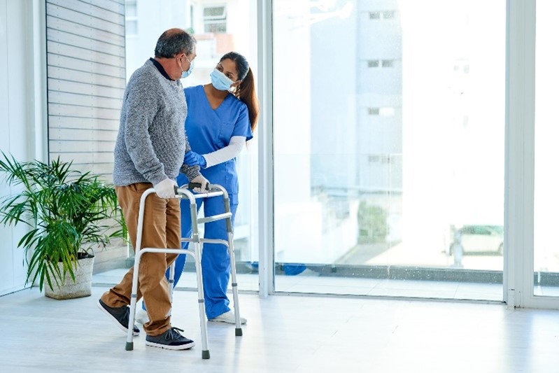 Female nurse assisting male patient